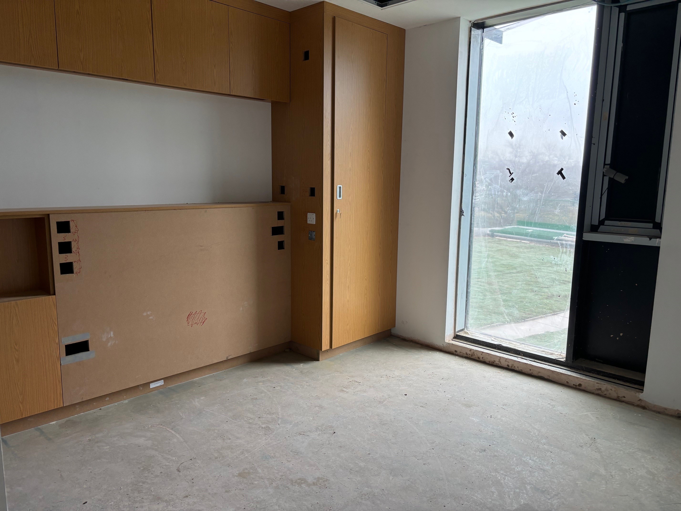 A patient bedroom with bare concrete floor