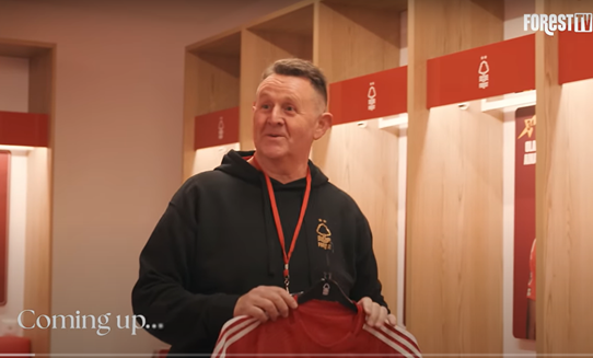 Harvey holds a Nottingham Forest shirt and smiles in the Forest changing room
